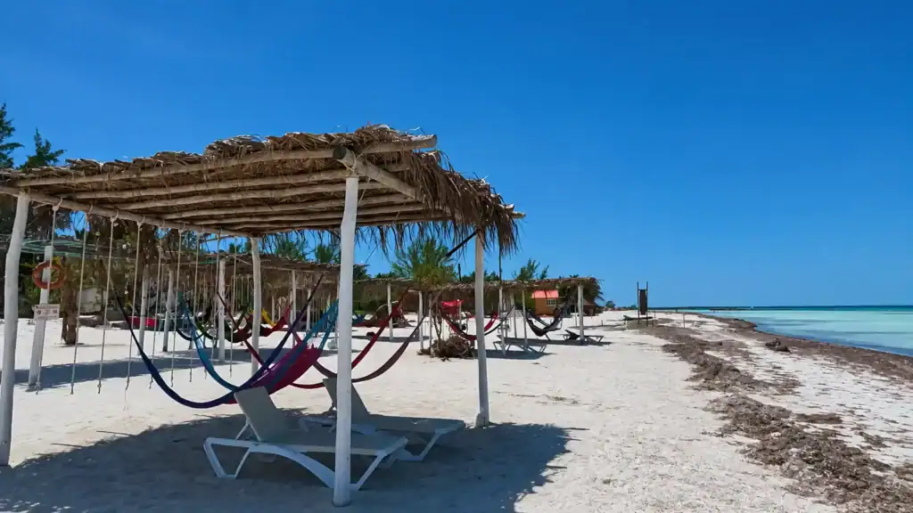 Colorful hammocks under a palapa on Holbox beach, ideal for the best time to visit Holbox