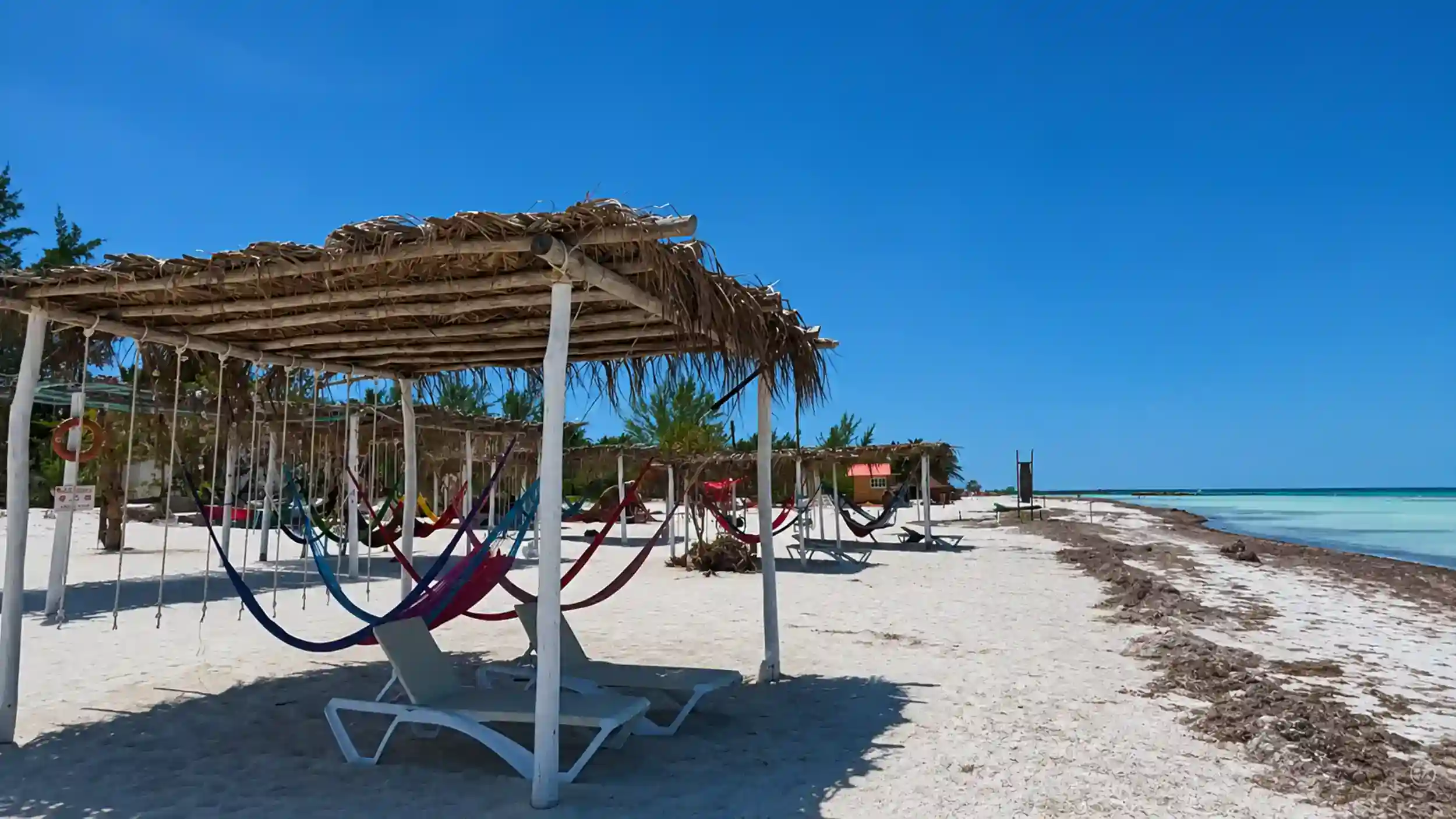 Colorful hammocks under a palapa on Holbox beach, ideal for the best time to visit Holbox