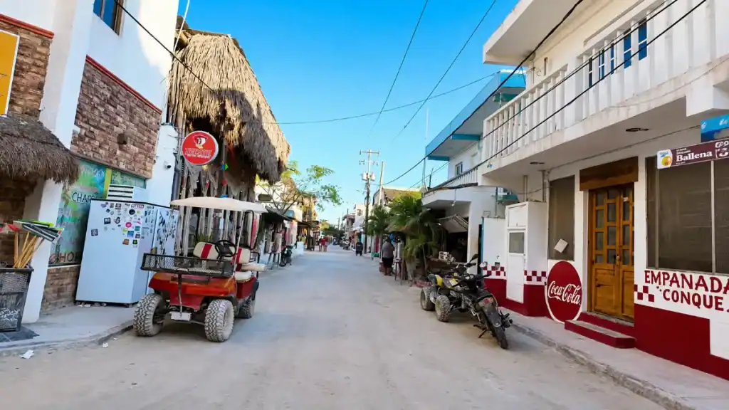 Golf carts and ATVs parked outside shops on Holbox's main street, key to getting around Holbox