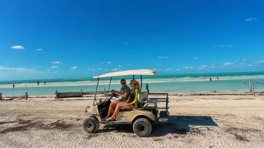 Couple in a beach golf cart, a popular option for getting around Holbox