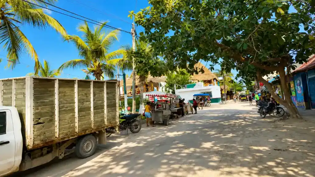 Sandy main street of Holbox town, best time to visit Holbox for shaded, motorbike-friendly streets