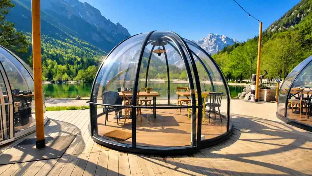 Glass dining dome overlooks the emerald water of Lake Jasna beneath the Julian Alps
