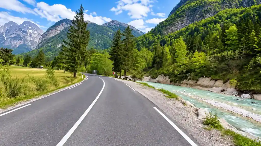A curving road toward Vršič Pass follows the turquoise Pišnica stream, proof that Kranjska Gora is worth visiting by car