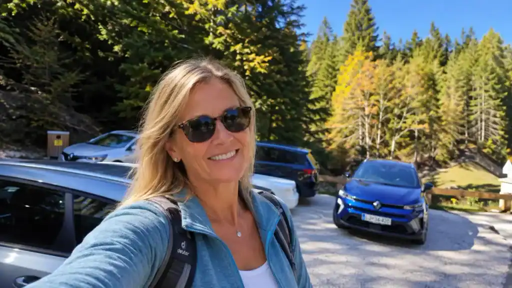A hiker pauses for a selfie at a parking area near the trailhead below the pass