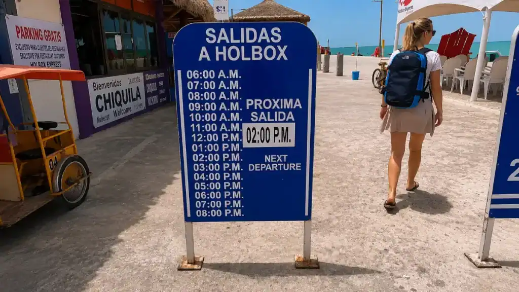 Ferry schedule sign showing hourly Salidas a Holbox departures, key info for how to get to Holbox