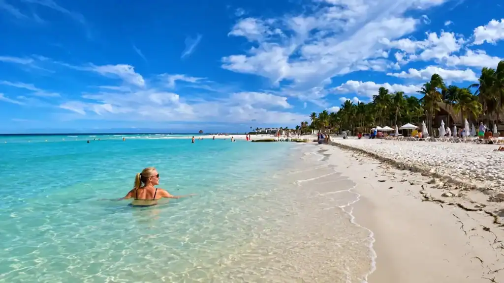 Woman wading in turquoise shallows along Playa Norte on Isla Mujeres