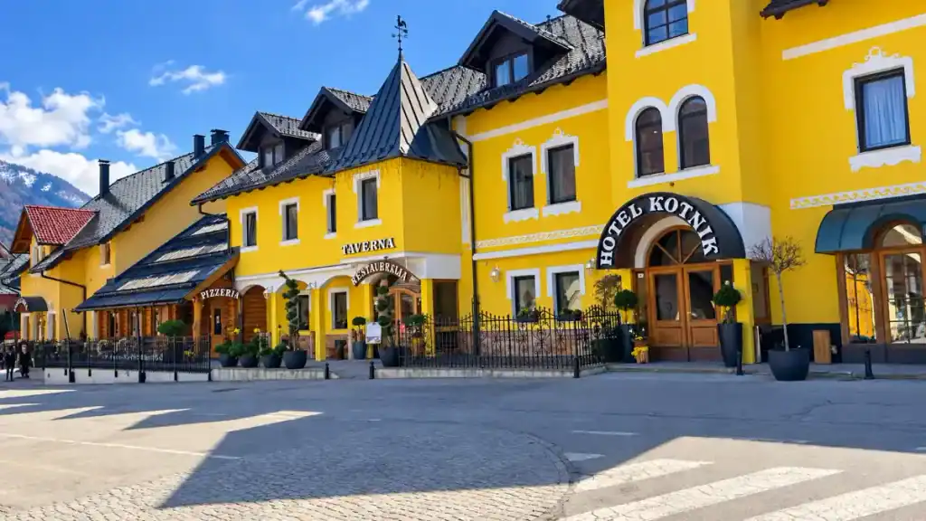 Hotel Kotnik's bright facade lines the village square, a common pick when weighing Kranjska Gora or Lake Bled for a home base