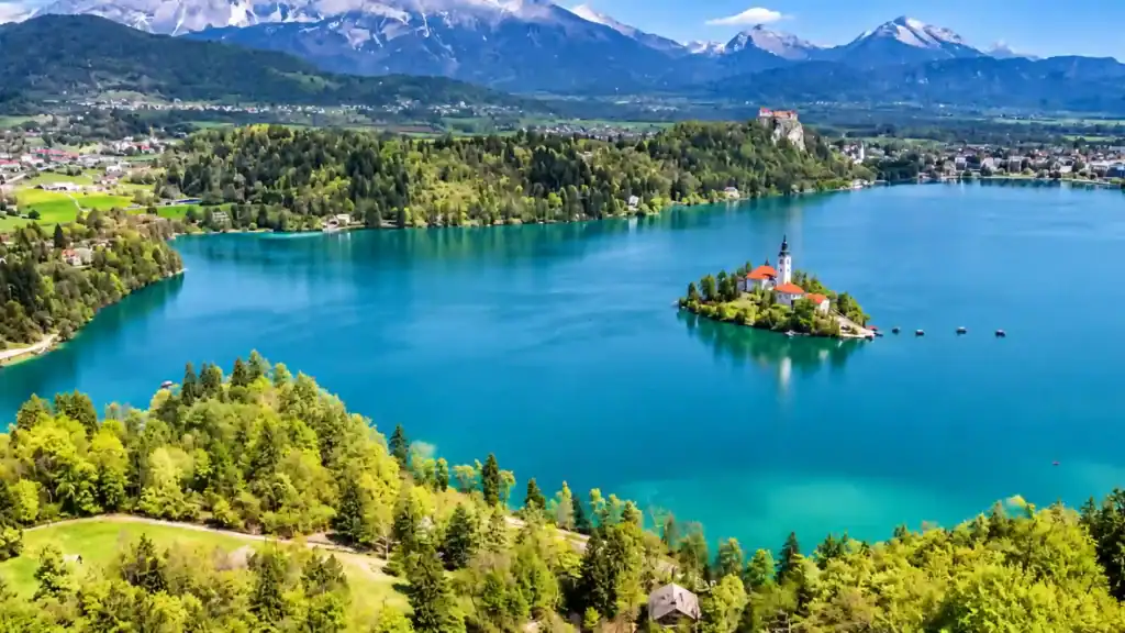 Bled Island's church rises from turquoise water below the castle cliff, the classic choice in Kranjska Gora or Lake Bled