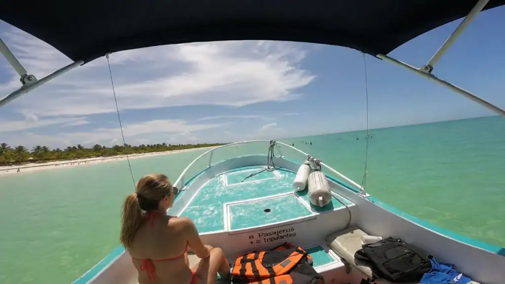 Woman aboard a small boat approaching Holbox's turquoise coastline