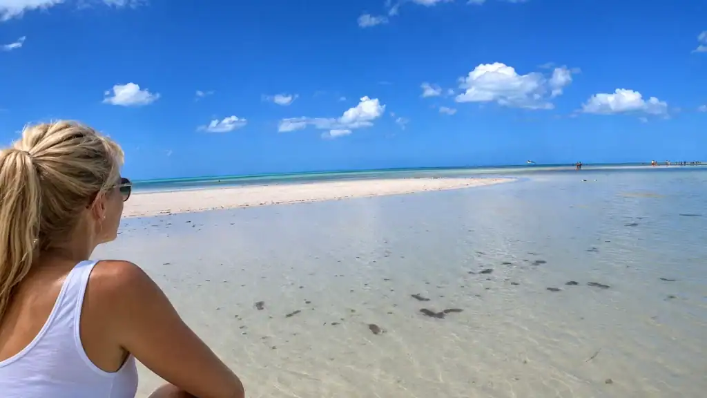 Woman gazes over the shallow sandbar waters at Punta Mosquito